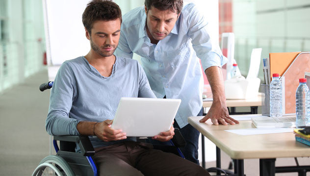 Man in wheelchair showing coworker something on his iPad